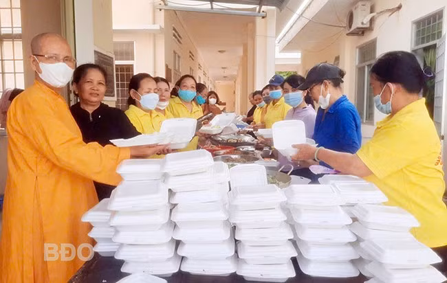 Ni sư Thích nữ Liên Hưng và nhóm thiện nguyện phát cơm từ thiện tại TTYT Phù Mỹ. Ảnh: V.T