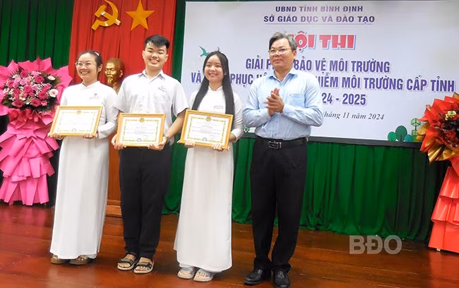 Ông Nguyễn Đình Hùng - Phó Giám đốc Sở GD&ĐT, Trưởng Ban giám khảo trao giải nhất cho nhóm tác giả đề tài “Một số sản phẩm khử mùi, đuổi côn trùng và “túi mầm xanh” thân thiện với môi trường”. Ảnh: V.L