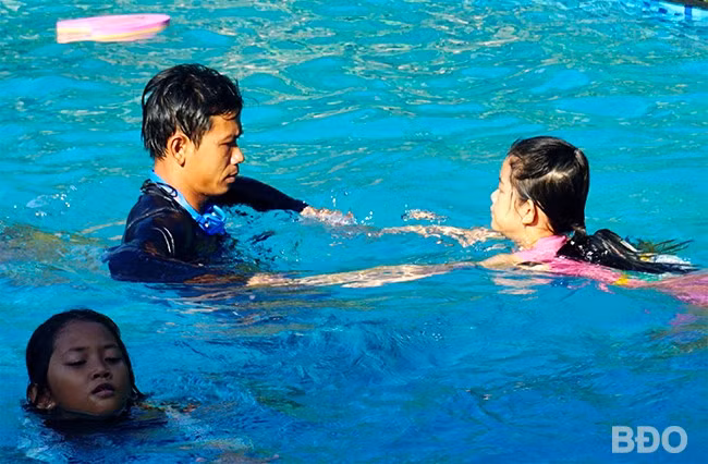 Thầy giáo tập bơi cho từng em ở lớp dạy bơi miễn phí tại huyện Vân Canh. Ảnh: T.K