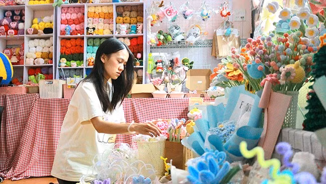 Nguyễn Lệ Khanh đang sắp xếp lại gian trưng bày sản phẩm len. Ảnh: TÀI NGÂN