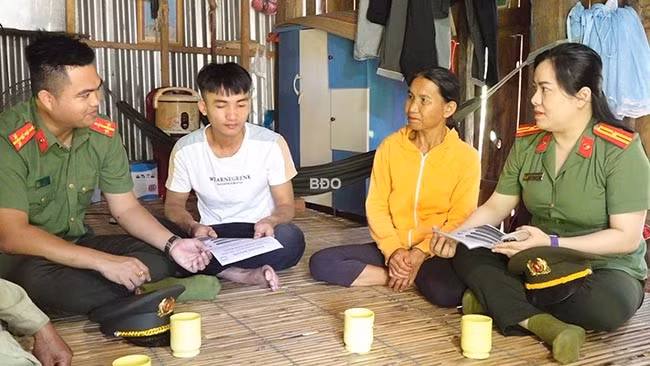 Lực lượng CA tuyên truyền về tội phạm trên không gian mạng tại gia đình anh Đinh Văn Vàng. Ảnh: M.N