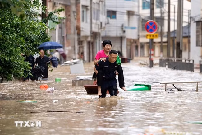 Lực lượng cứu hộ hỗ trợ người dân sơ tán khỏi khu vực ngập lụt tại huyện Tòng Giang, tỉnh Quý Châu, Trung Quốc ngày 24.6.2025. (Ảnh: THX/TTXVN)