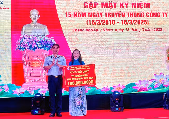Lãnh đạo Công ty CP Tân Cảng miền Trung trao bảng tượng trưng ủng hộ Quỹ Vì người nghèo tỉnh Bình Định 100 triệu đồng. Ảnh: HẢI YẾN
