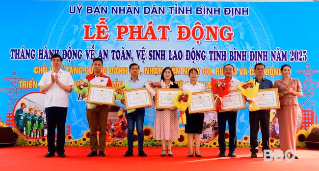 Phó Chủ tịch UBND tỉnh Lâm Hải Giang (bìa trái) và Phó Chủ tịch HĐND tỉnh Huỳnh Thúy Vân (bìa phải) tặng Bằng khen của UBND tỉnh cho các tập thể có thành tích xuất sắc tiêu biểu trong thực hiện công tác ATVSLĐ. Ảnh: N.M.