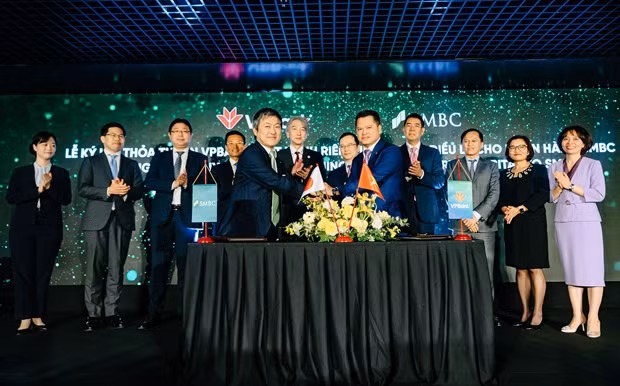 Ông Ngô Chí Dũng, Chủ tịch HĐQT VPBank (bên phải) và ông Masahiro Yoshimura, Giám đốc điều hành, Tổng trưởng Quản lý Đầu tư, Ngân hàng SMBC ký kết thỏa thuận. (Ảnh: Vietnam+)