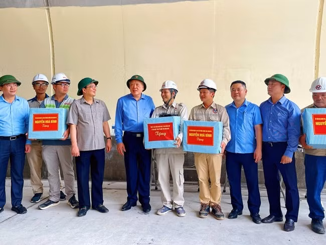 Phó Thủ tướng Thường trực Chính phủ Nguyễn Hòa Bình và lãnh đạo tỉnh tặng quà cho các công nhân đang thi công tại hầm Sơn Triệu. Ảnh: HẢI YẾN