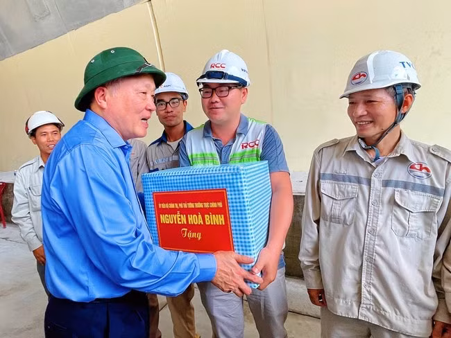 Phó Thủ tướng Thường trực Chính phủ Nguyễn Hòa Bình (bìa trái), trao quà cho công nhân đang thi công tại hầm Sơn Triệu. Ảnh: HẢI YẾN