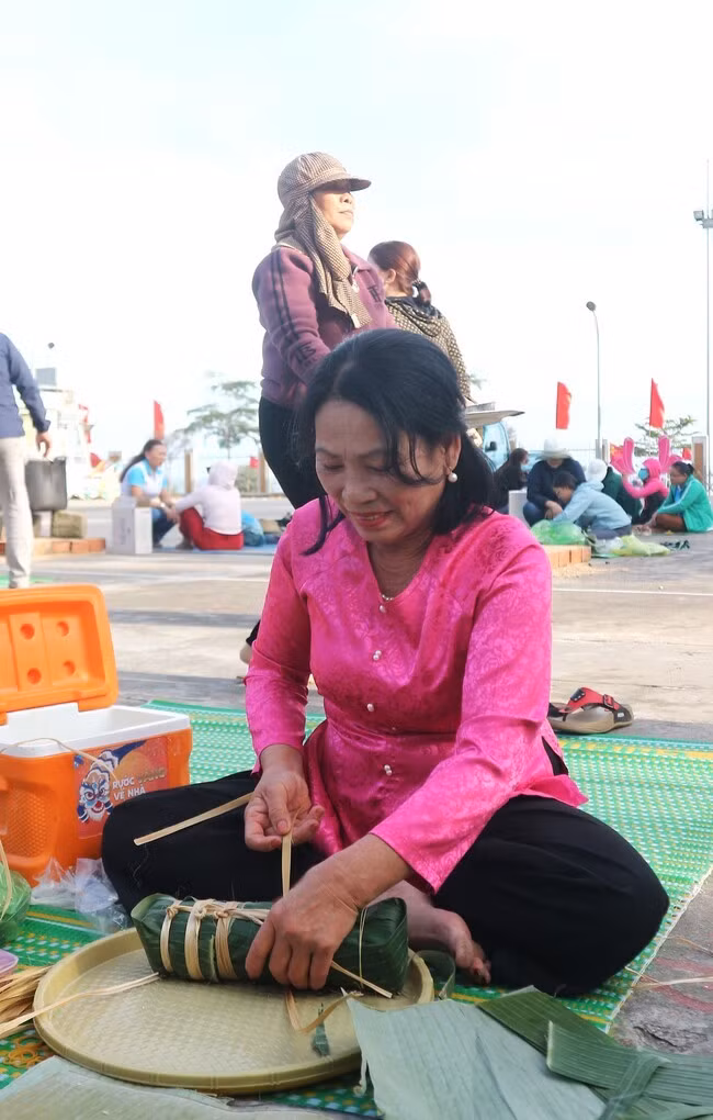 Các đội thi tỉ mỉ gói bánh đảm bảo yêu cầu kỹ thuật và mỹ thuật, với nhân bánh nằm ở vị trí trung tâm; bên ngoài vuông vắn đối với bánh chưng và bánh tét phải tròn đều. Ảnh: K.VY