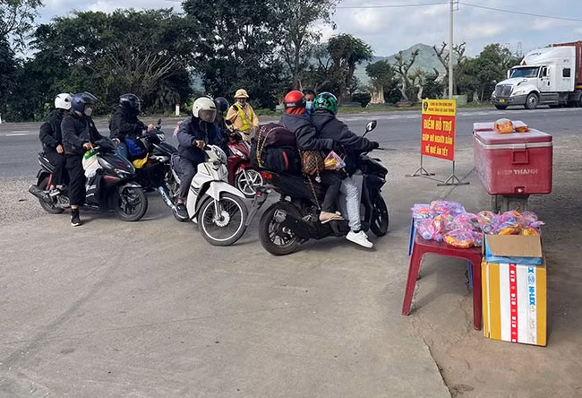 Điểm hỗ trợ nước uống, khăn lạnh, bánh ngọt cho người dân trên đường về quê đón Tết trên QL 1 (trước Trạm CSGT Tuy Phước). Ảnh: THU HÀ
