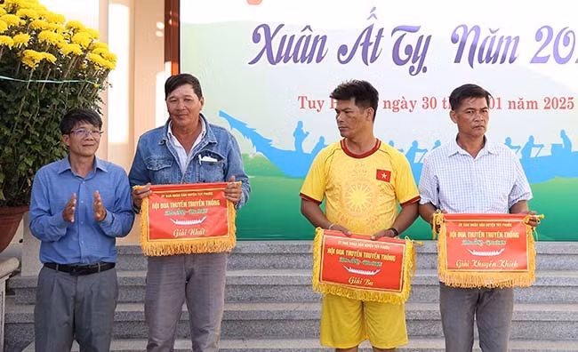 Ban tổ chức trao giải cho các đội đạt thành tích cao nội dung đua thuyền truyền thống nam. Ảnh: N.DŨNG