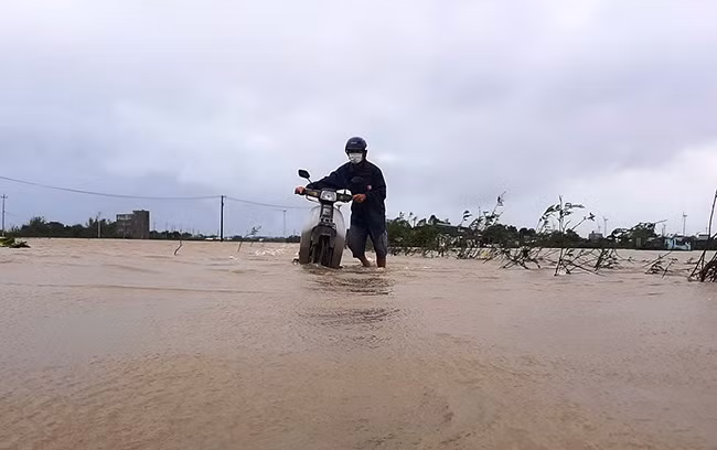 Dắt xe máy di chuyển trong lũ Dắt xe máy di chuyển trong lũ