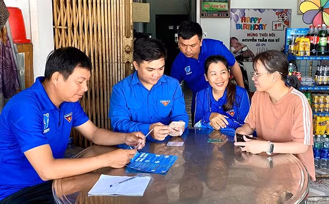 Đoàn viên, thanh niên phường Tam Quan hỗ trợ người dân thực hiện tuyến đường thanh toán không tiền mặt. Ảnh: D.L
