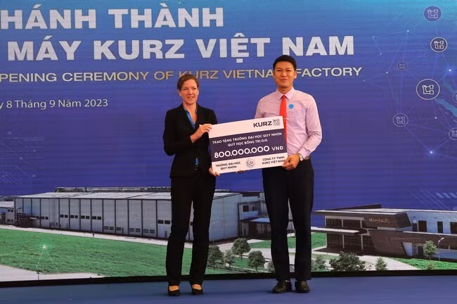 Công ty TNHH KURZ Việt Nam trao tặng tiền cho quỹ học bổng huyện Vân Canh và Trường Đại học Quy Nhơn. Ảnh: TIẾN SỸ