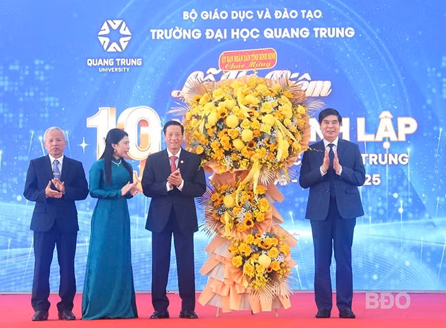 Lãnh đạo tỉnh tặng hoa chúc mừng Trường ĐH Quang Trung. Ảnh: HỒ ĐIỂM