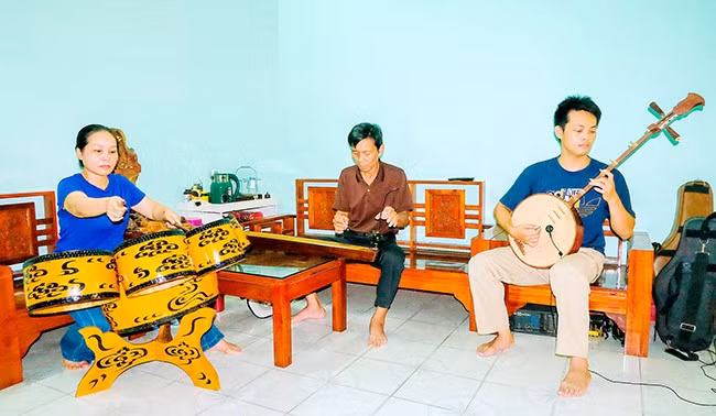 Nghệ sĩ Đỗ Anh Bình (giữa) cùng vợ và con trai tập luyện tiết mục biểu diễn. Ảnh: NGỌC NHUẬN