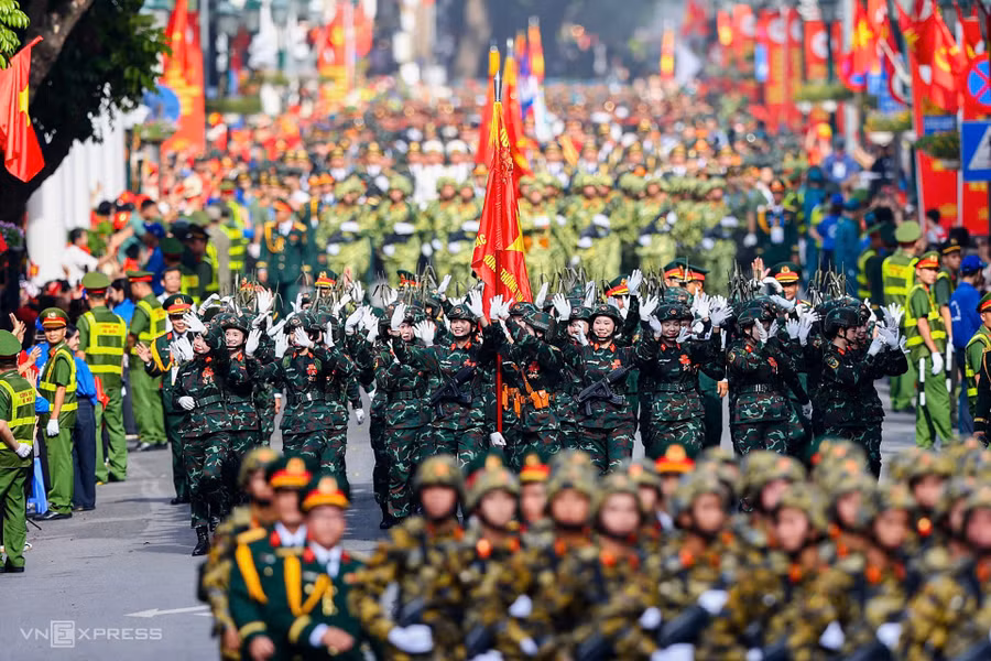 Đoàn nữ chiến sĩ Thông tin liên lạc vẫy tay chào người dân hai bên phố Tràng Tiền. Ảnh: Quỳnh Trần/VnEpress