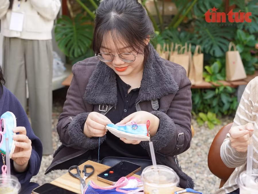 Bạn Nông Mỹ Phương Thảo thử trải nghiệm làm phụ kiện mini trang trí bằng chiếc giày của đồng bào dân tộc Giáy.