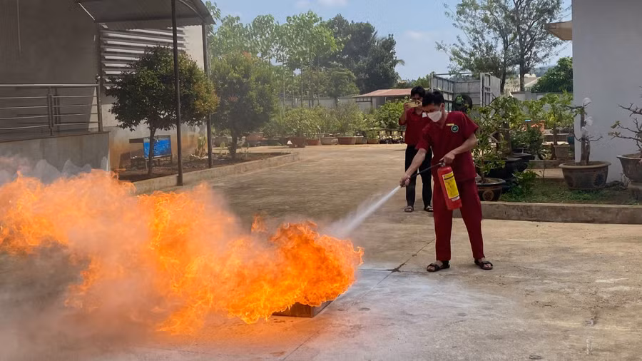 Cán bộ, nhân viên Công ty TNHH Bệnh viện Mắt Cao Nguyên thực hành dùng bình chữa cháy dập tắt đám cháy. Ảnh: Trần Lương