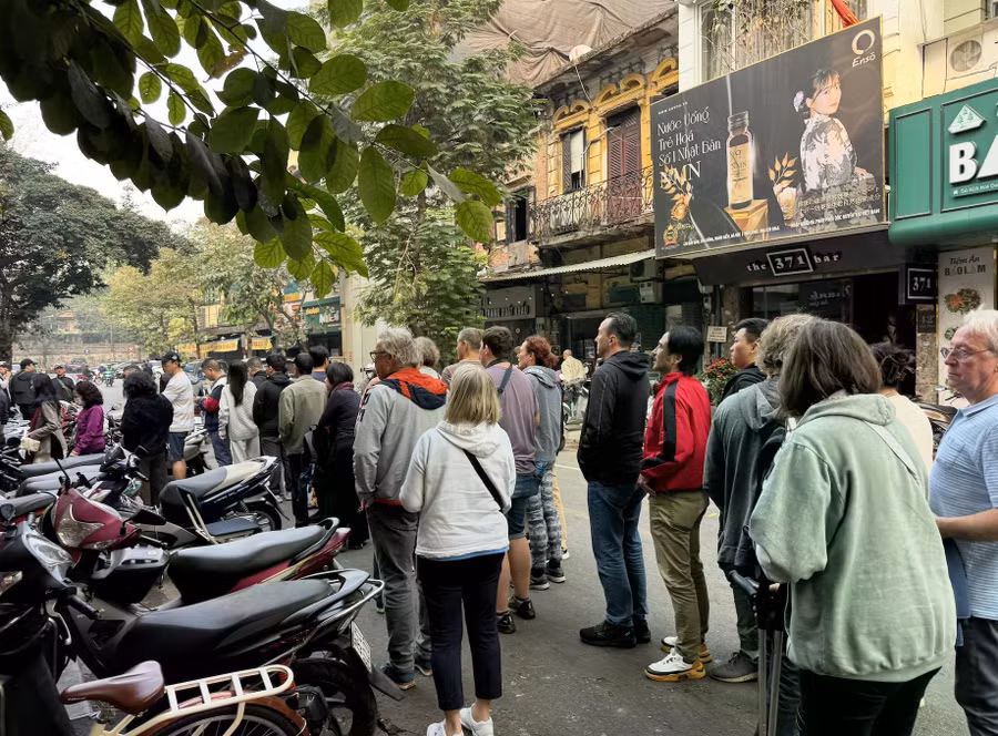 Khách nước ngoài xếp hàng ăn phở Bát Đàn trên phố cổ Hà Nội. Ảnh: Lê Nam