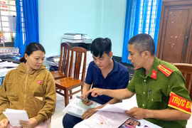 Cán bộ Công an phường An Nhơn Nam hướng dẫn, hỗ trợ người dân thực hiện thủ tục đăng ký thường trú cho con qua ứng dụng VNeID. Ảnh: Nguyễn Chơn