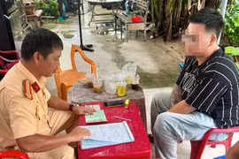 Cán bộ CSGT lập biên bản xử lý tài xế đỗ ô tô ngược chiều trên đường phố Quy Nhơn.