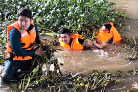 Cán bộ, chiến sĩ và người dân cùng vớt lục bình và rác để khơi thông dòng chảy