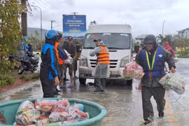 Hàng hóa được đưa lên thuyền thúng vận chuyển vào tiếp tế cho các hộ dân còn bị cô lập. Q.T