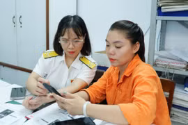 Với sự hỗ trợ của cơ quan thuế, nhiều hộ kinh doanh ở phường Quy Nhơn đã cài đặt và sử dụng ứng dụng eTax Mobile trên điện thoại di động. Ảnh: T.Sỹ