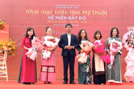 Nghệ sĩ Ưu tú Đặng Công Hưng-Chủ tịch Hội Văn học Nghệ thuật Gia Lai tặng hoa cho các nữ họa sĩ đại diện 3 miền Bắc-Trung-Nam góp mặt tại triển lãm. Ảnh: Phương Duyên