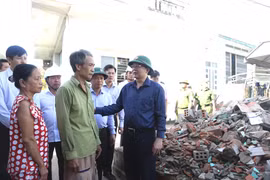 Phó Thủ tướng Hồ Quốc Dũng (bìa phải) thăm, động viên gia đình ông Trịnh Ngọc Tùng (thôn Tùng Giản, xã Tuy Phước Đông).