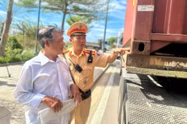 Cán bộ Đội Cảnh sát giao thông đường bộ số 4 nhắc nhở tài xế về các điểm chưa đảm bảo tại chốt giữ của container. Ảnh: K.A