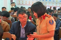 Cán bộ CSGT hướng dẫn thí sinh cài đặt ứng dụng VNeTraffic