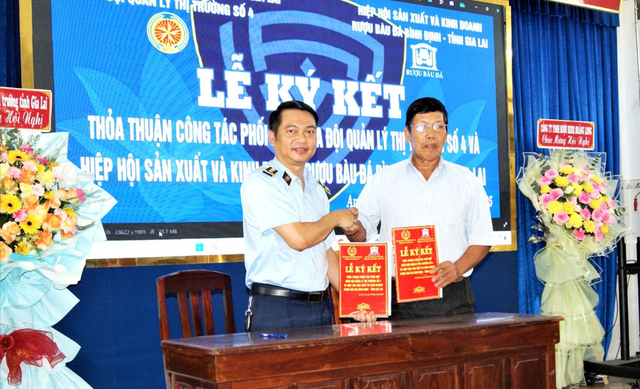 Đại diện Đội Quản lý thị trường số 4 và Hiệp hội Sản xuất và kinh doanh rượu Bàu Đá Bình Định ký kết thỏa thuận công tác phối hợp. Ảnh: Văn Lực pho-bien-phap-luat-trong-linh-vuc-san-xuat-kinh-doanh-ruou-thu-cong.jpg