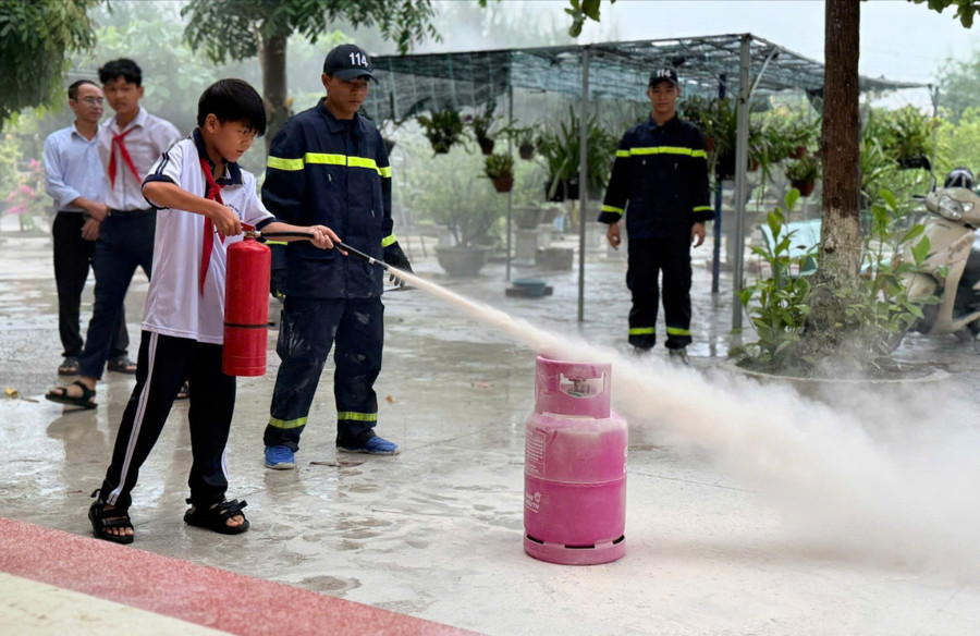 Học sinh Trường THCS Nhơn Hội trải nghiệm cách dập lửa do cháy bình gas. Ảnh: N.L hoc-sinh-trai-nghiem-dung-binh-chua-chay-xach-tay.jpg