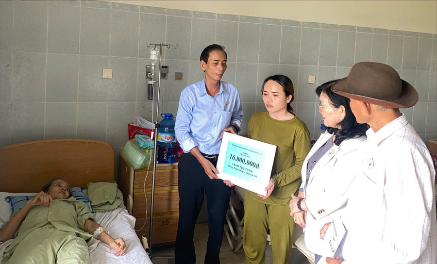 Ông Trần Đình Ký, Phó Chủ tịch Hội bảo trợ Bệnh nhân nghèo tỉnh Gia Lai trao bảng tượng trưng số tiền hỗ trợ cho bà Bảy. Ảnh: Ánh Hồng z6909782817575-35365fa8978b9b59d311a823c960e115.jpg