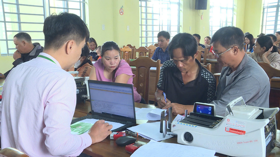 Gia đình bà Lương Thị Huyền và ông Trương Văn Trung được hướng dẫn thủ tục giải ngân khoản vay STEM. Ảnh: Huy Toàn z7037667692939-fd50f8f0c3d5a79cc17ea0155b1e99b9.jpg