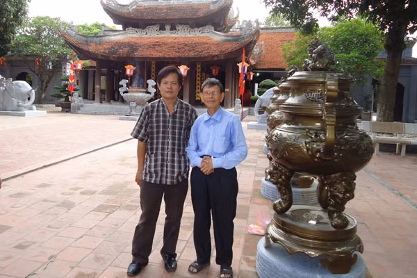 Tác giả cùng ông Nguyễn Đức Thìn (bên phải) trước đền Đô. Ảnh: Q.N