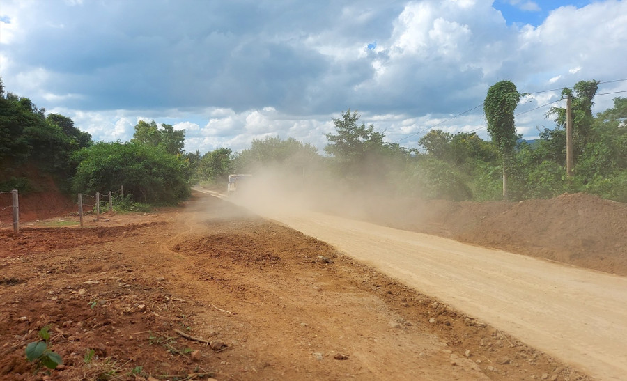 Đoạn đường liên xã bị đất, đá ở điểm khai thác tràn xuống đường, gây mịt mù bụi trong mùa khô, lầy lội, trơn trượt trong mùa mưa. Ảnh: Phan Tuấn