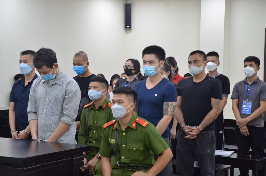 Nguyễn Xuân Quý (áo xám, hàng đầu) chủ mưu vụ mở phòng bay lắc, bán ma tuý tại Bệnh viện Tâm thần Trung ương I và 9 bị cáo trong phiên toà sơ thẩm. Ảnh: V.D
