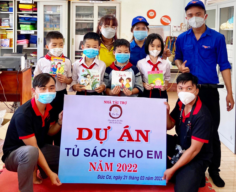 Anh Lê Tuấn Thành (hàng trước, bìa trái) tặng tủ sách cho trường học ở huyện Đức Cơ. Ảnh: Minh Nhật