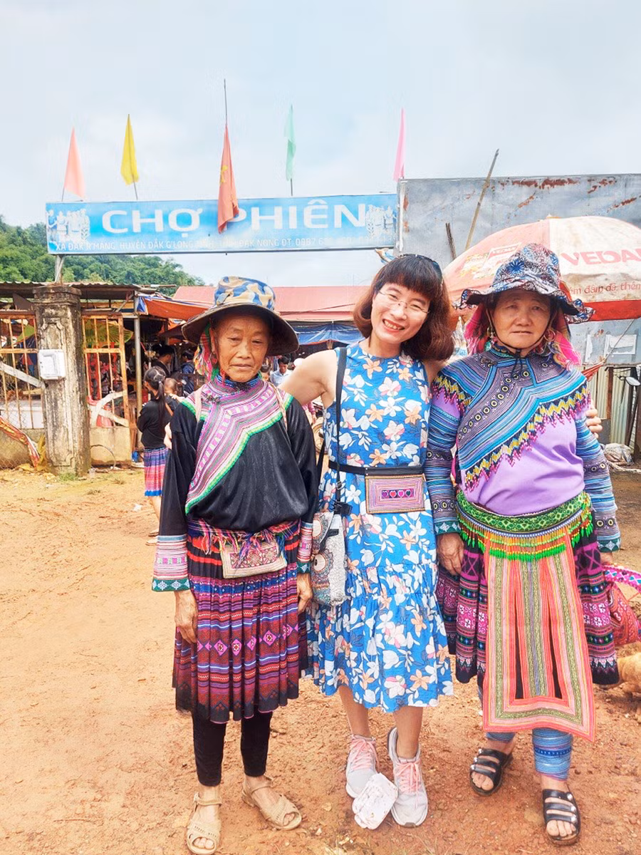  Tác giả (ở giữa) chụp ảnh tại chợ phiên. Ảnh: Tạ Ngọc Điệp