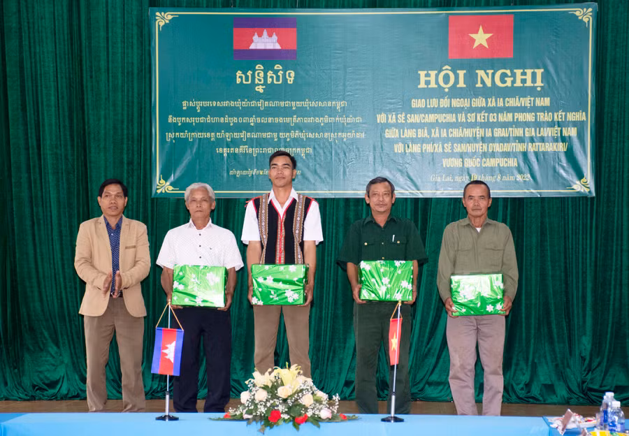 Chủ tịch UBND xã Ia Chía Rah Lan Gâu (đầu tiên bìa trái) tặng quà cho Lãnh đạo xã Sê San. Ảnh: Đinh Yến