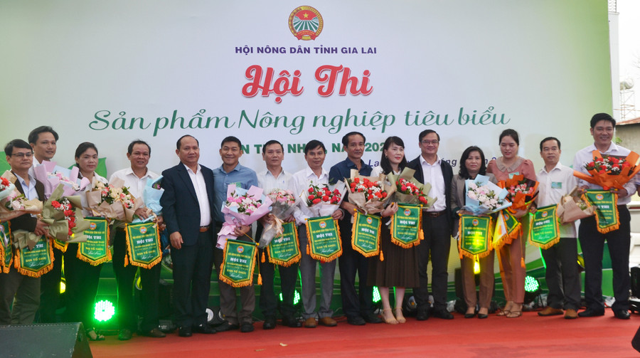  Đồng chí Rah Lan Chung-Phó Bí thư Tỉnh ủy (thứ 5 bên trái) và đồng chí Võ Anh Tuấn-Chủ tịch Hội Nông dân tỉnh (thứ 5 bên phải) tăng hoa chúc mừng những cán bô, hội viên nông dân tham gia hội thi. Ảnh: Hoàng Minh