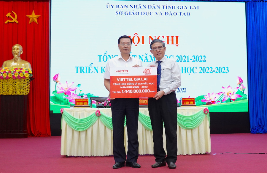 Giám đốc Viettel Gia Lai Trần Văn Thuân (bìa trái) trao bảng tượng trưng tặng học bổng 