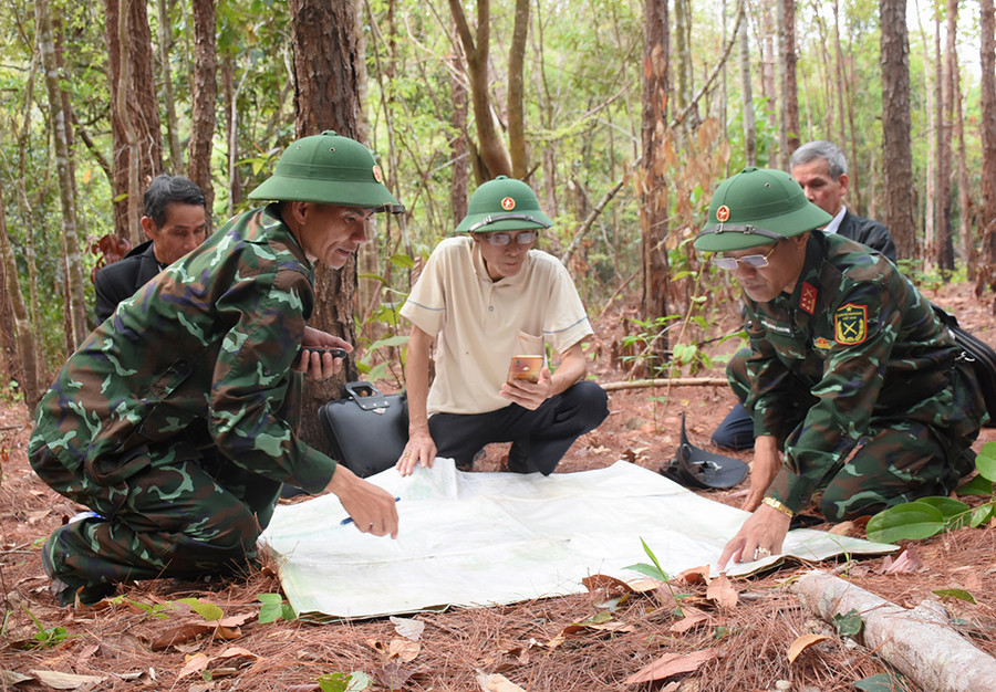 Đội Quy tập mộ liệt sĩ cùng thân nhân liệt sĩ xem tọa độ trên bản đồ, xác định vị trí, khu vực tìm kiếm. Ảnh: Minh Nguyễn