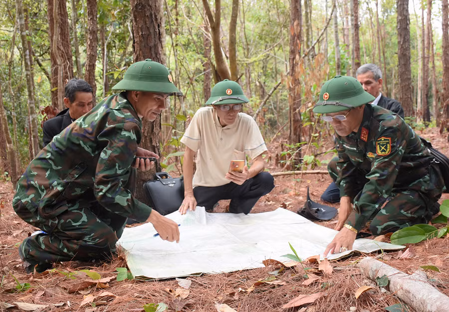 Đội Quy tập mộ liệt sĩ cùng thân nhân liệt sĩ xem tọa độ trên bản đồ, xác định vị trí, khu vực tìm kiếm. Ảnh: Minh Nguyễn