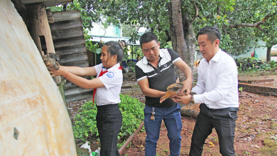 Em Rah Lan H’Sila (bìa trái; Trường THCS Lý Tự Trọng, xã Ia Kla, huyện Đức Cơ) nhận đàn gà “Khăn quàng đỏ” do Hội đồng Đội tỉnh và các nhà tài trợ trao tặng. Ảnh: Minh Nhật