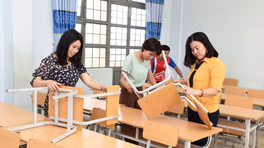 Giáo viên Trường THCS Nguyễn Huệ (phường Hội Thương, TP. Pleiku) vệ sinh bàn ghế lớp học chuẩn bị cho năm học mới. Ảnh: Đức Thụy