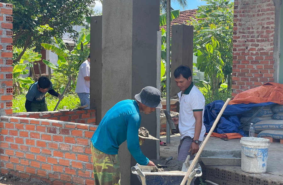 Anh Đinh Văn Bồi (áo xanh) cùng nhóm thợ thi công nhà dân ở xã Kông Bờ La. Ảnh: Thiên Di