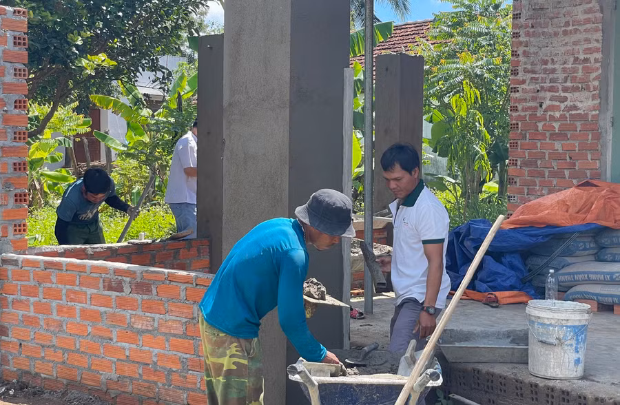 Anh Đinh Văn Bồi (áo xanh) cùng nhóm thợ thi công nhà dân ở xã Kông Bờ La. Ảnh: Thiên Di